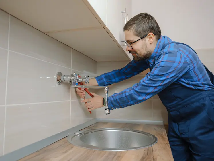 Local plumber fixing a fitting in Preston
